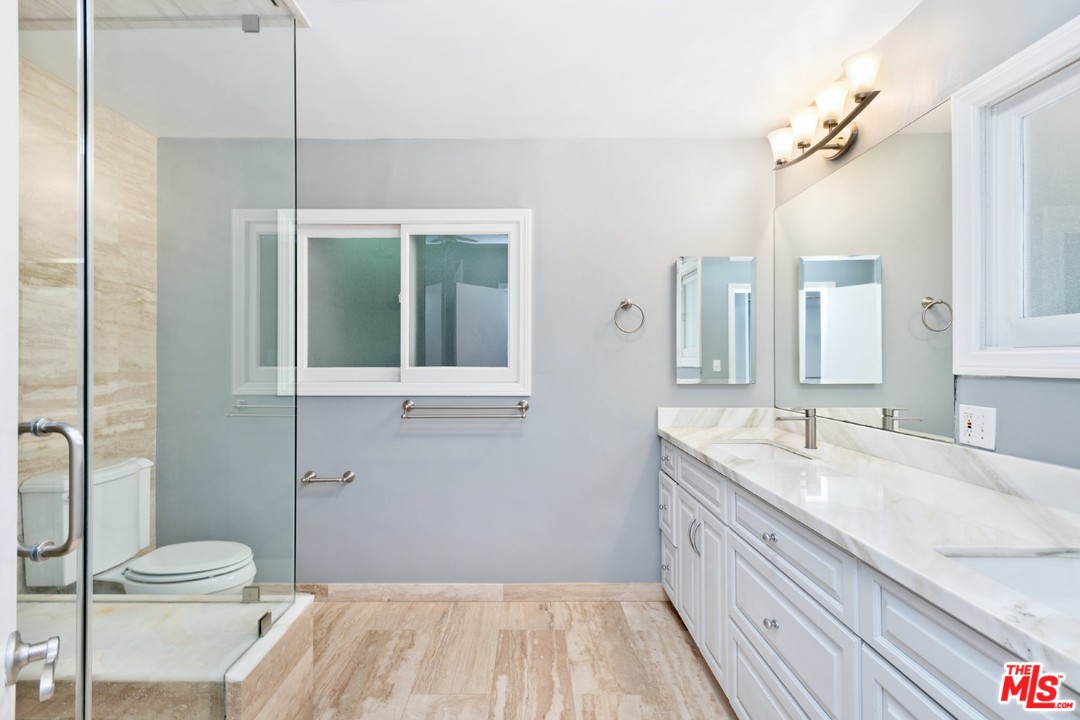 9614 Heather Road Beverly Hills, CA 90210 - Photo 18 of 25 a bathroom with a sink a toilet and a large mirror
