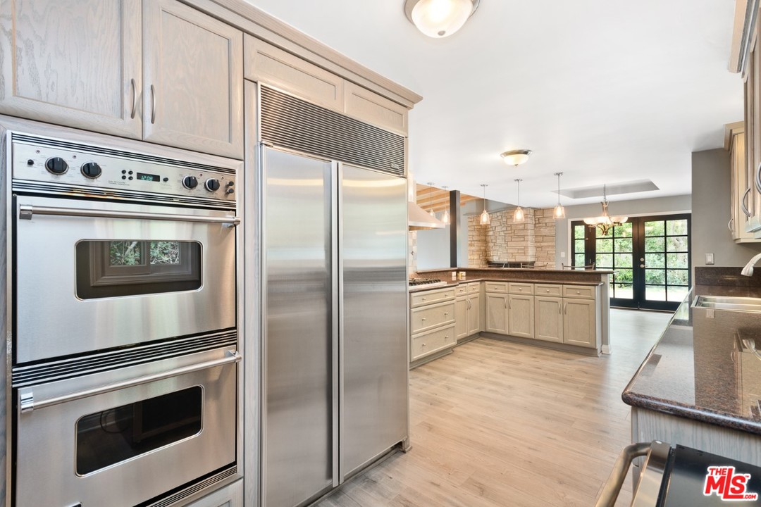 9614 Heather Road Beverly Hills, CA 90210 - Photo 2 of 25 a kitchen with granite countertop white cabinets and stainless steel appliances