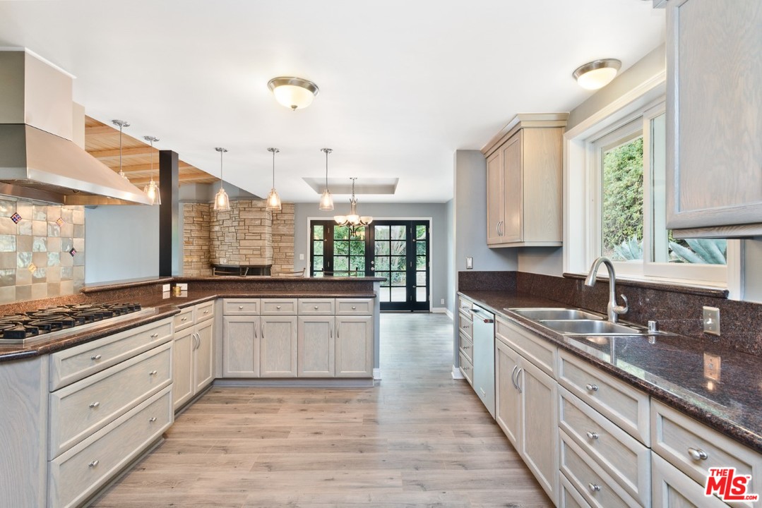 9614 Heather Road Beverly Hills, CA 90210 - Photo 3 of 25 a large kitchen with granite countertop a sink and cabinets