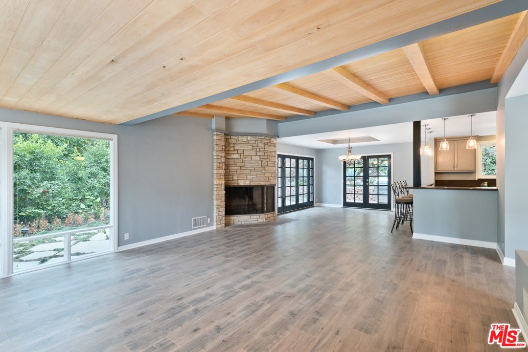 9614 Heather Road Beverly Hills, CA 90210 - Photo 7 of 25 a view of an empty room with wooden floor and a window