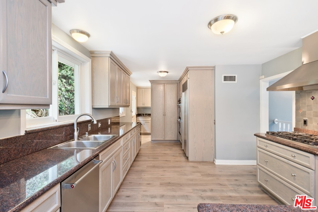 9614 Heather Road Beverly Hills, CA 90210 - Photo 8 of 25 a kitchen with a sink and a stove top oven