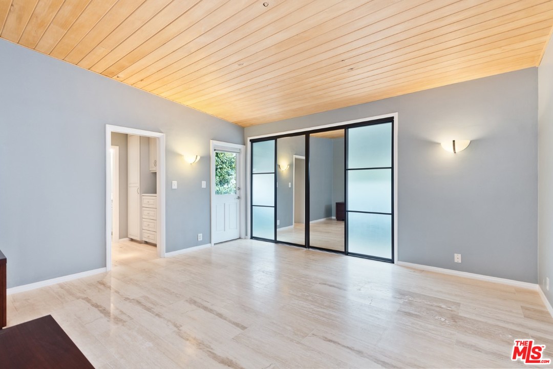 9614 Heather Road Beverly Hills, CA 90210 - Photo 10 of 25 a view of an empty room with wooden floor and a window