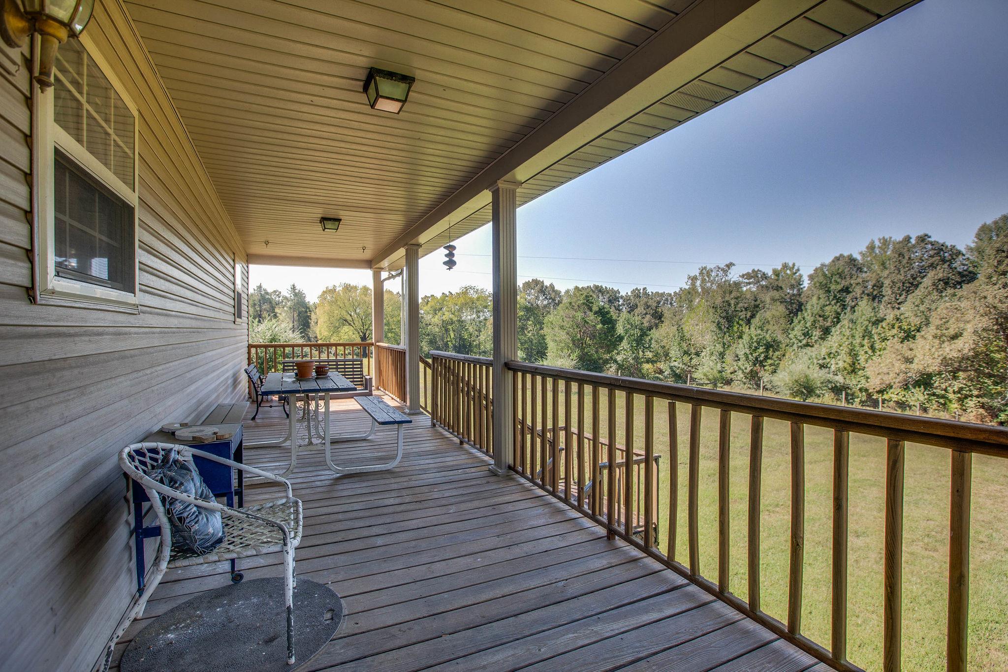 8120 Primm Springs Road Primm Springs, TN 38476 - Photo 23 of 27 a balcony with wooden floor table and chairs