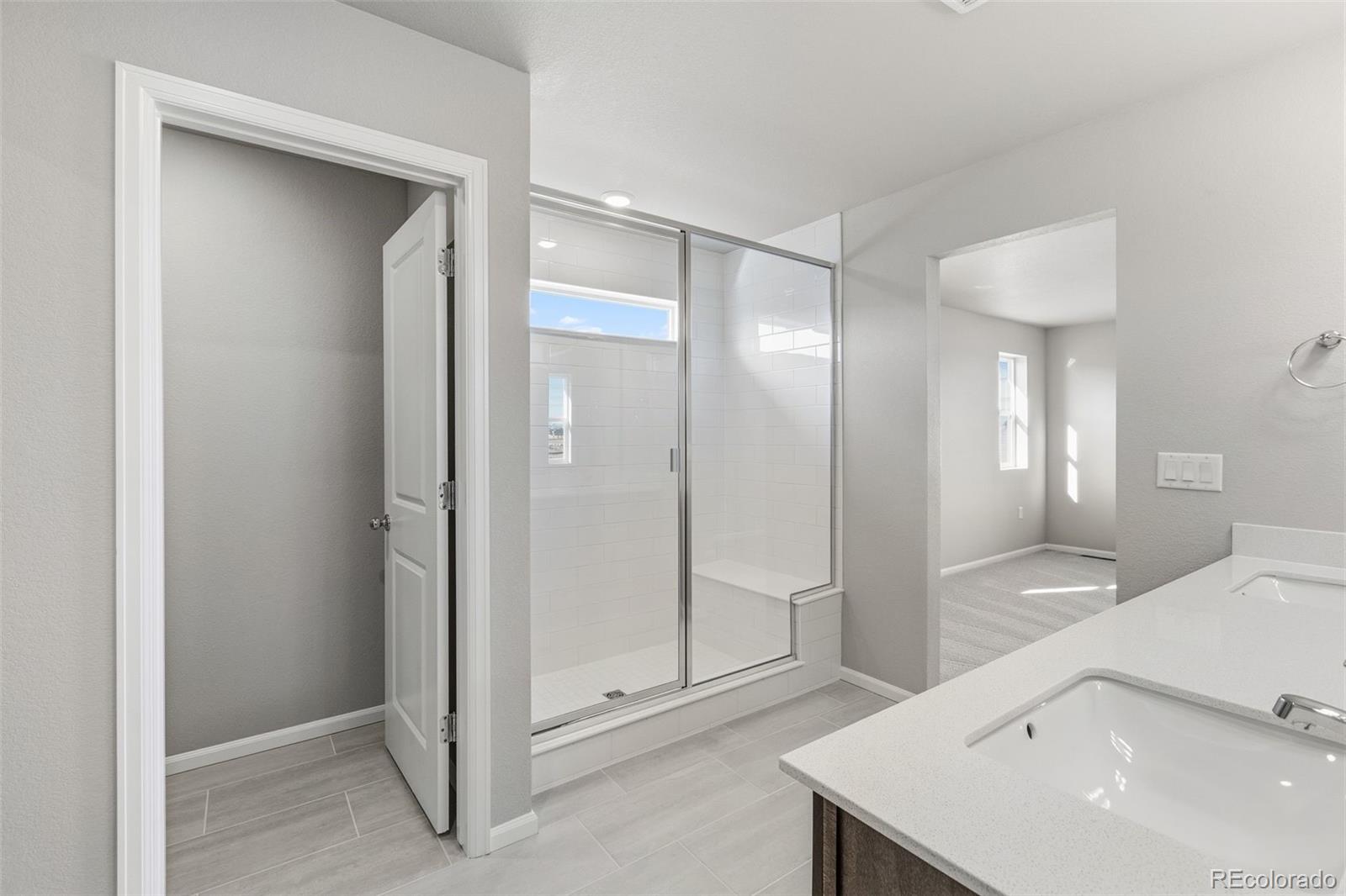 15293 Olive Way Thornton, CO 80602 - Photo 17 of 29 a spacious bathroom with a shower and a sink