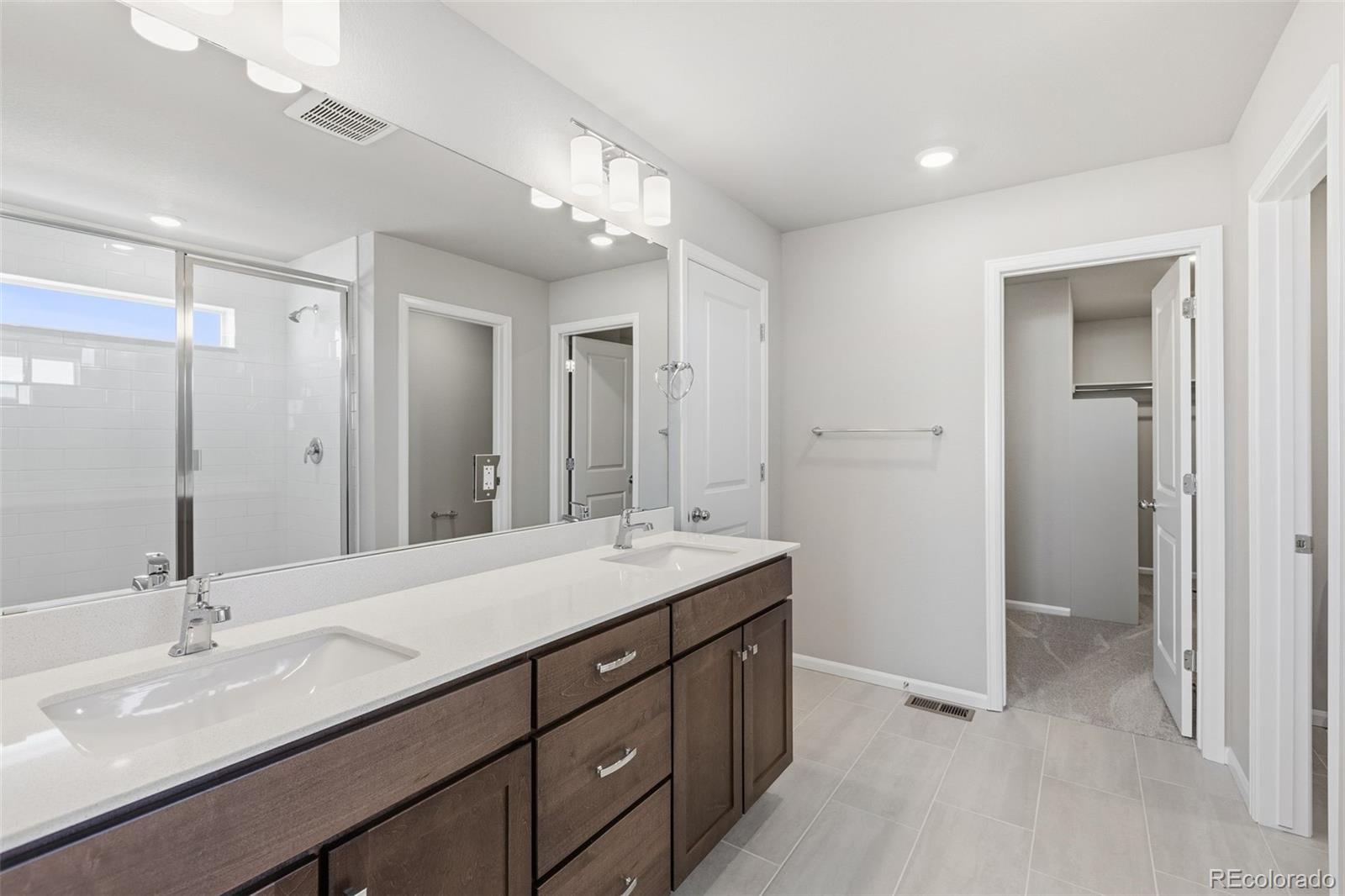 15293 Olive Way Thornton, CO 80602 - Photo 18 of 29 a bathroom with a sink double vanity and a mirror