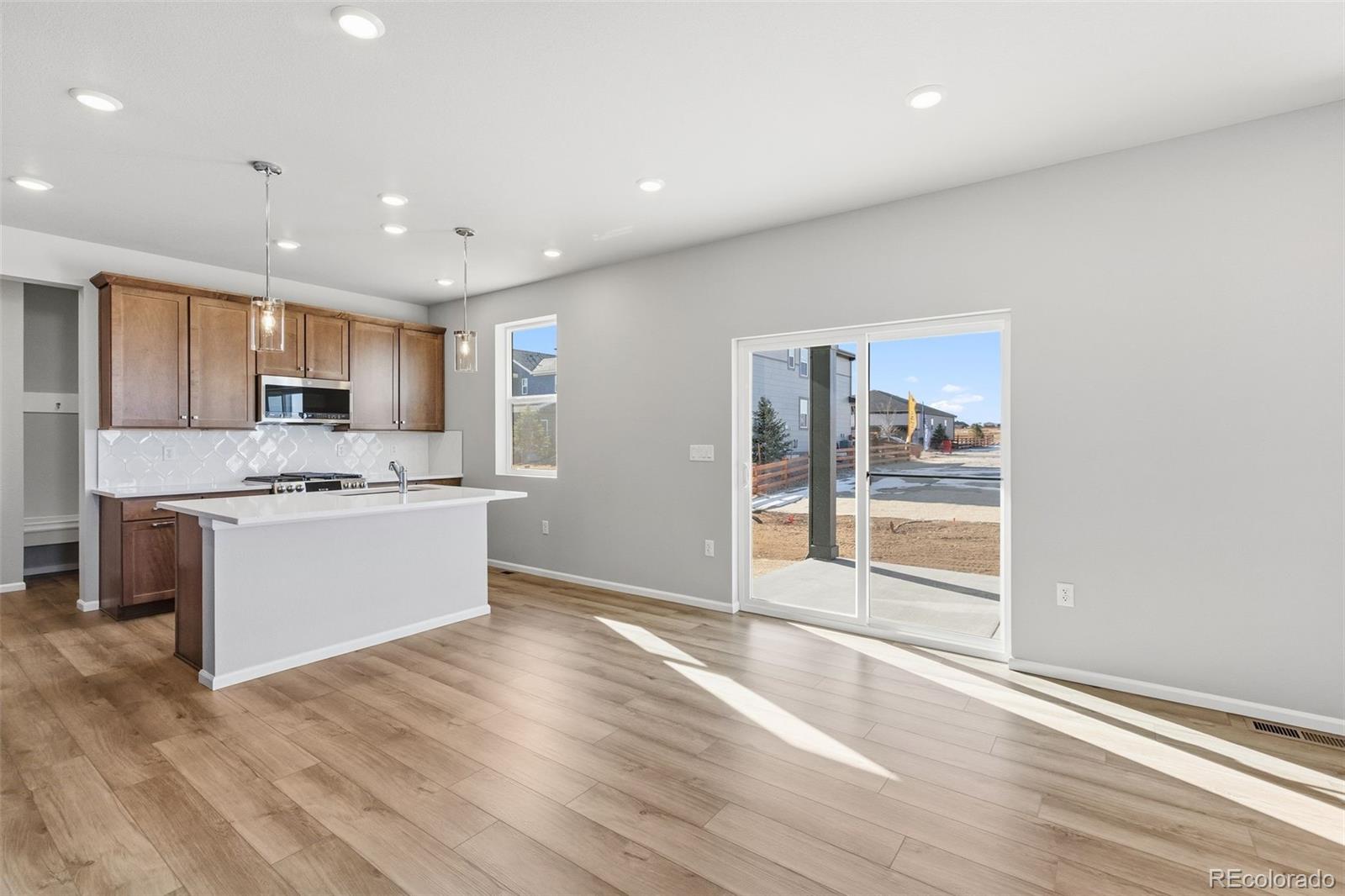 15293 Olive Way Thornton, CO 80602 - Photo 7 of 29 a large kitchen with kitchen island a sink stainless steel appliances and cabinets