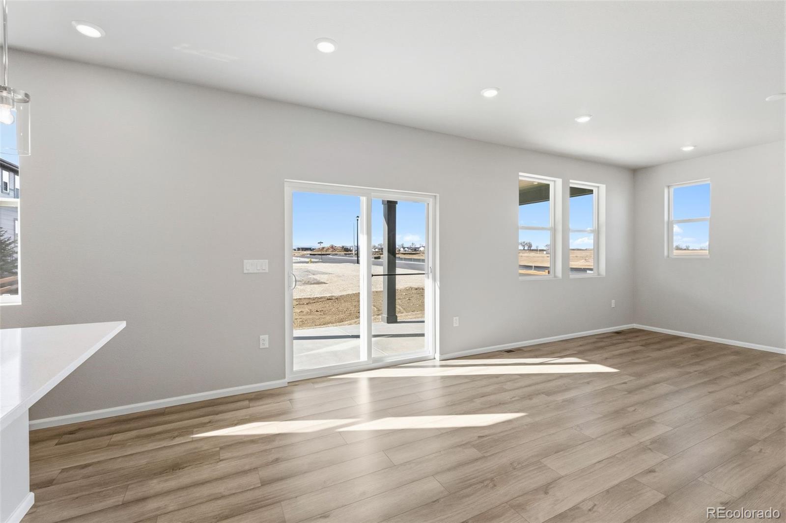 15293 Olive Way Thornton, CO 80602 - Photo 8 of 29 an empty room with wooden floor and windows