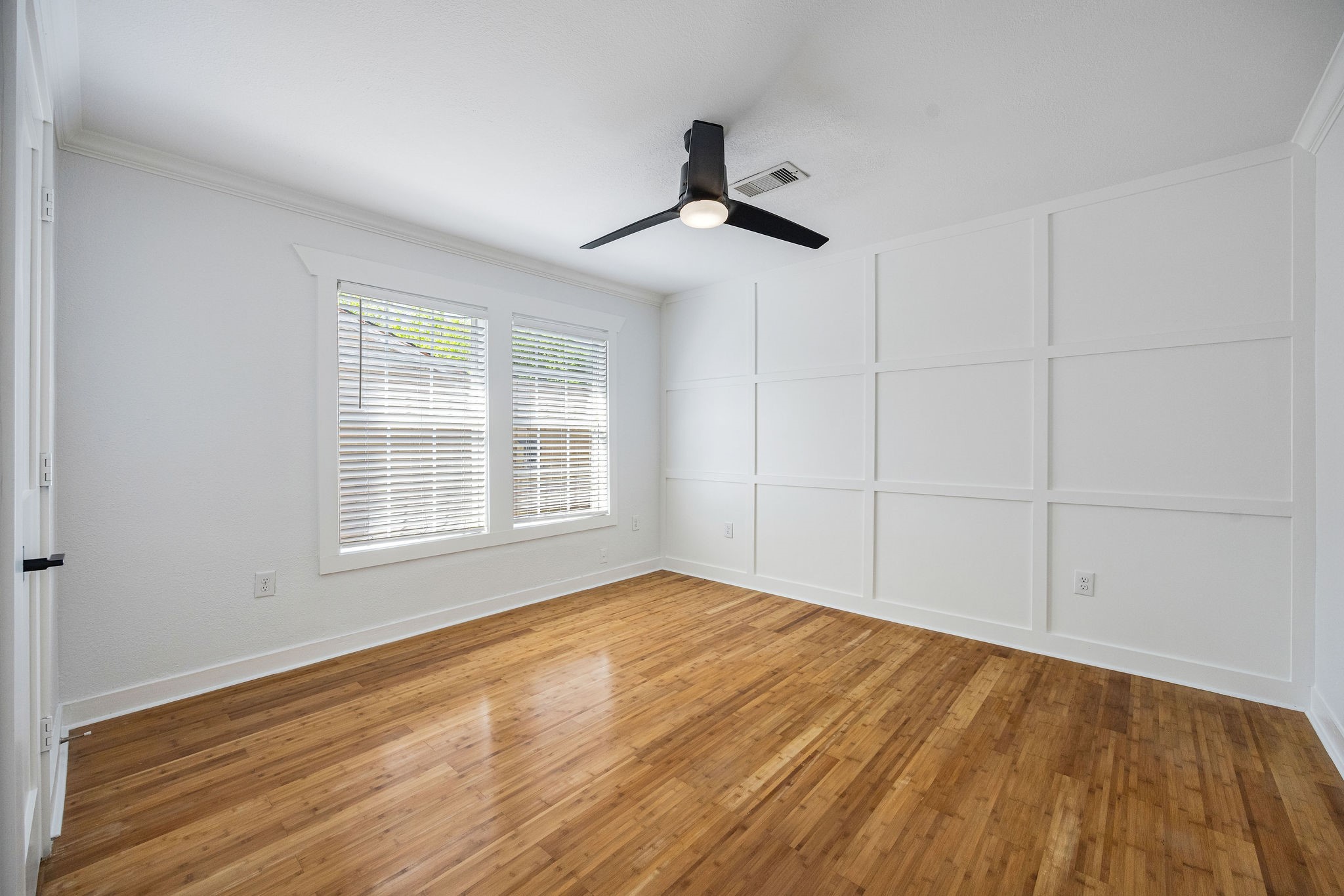 1310 Walton Street Houston, TX 77009 - Photo 13 of 19 Secondary bedroom with natural light, hardwood flooring, and custom accent wall detail.
