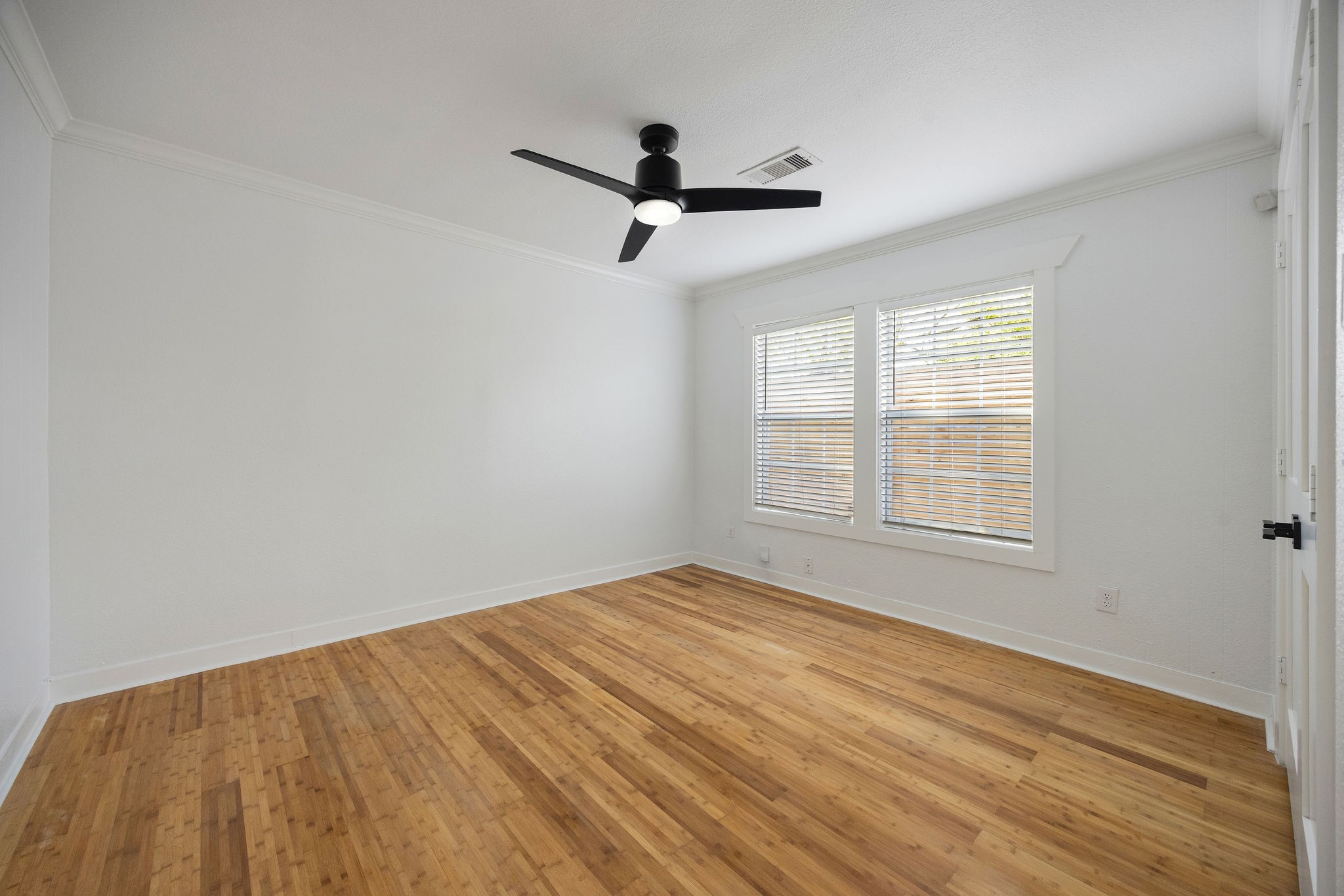 1310 Walton Street Houston, TX 77009 - Photo 15 of 19 Bright bedroom with clean finishes, large windows, and hardwood flooring throughout.