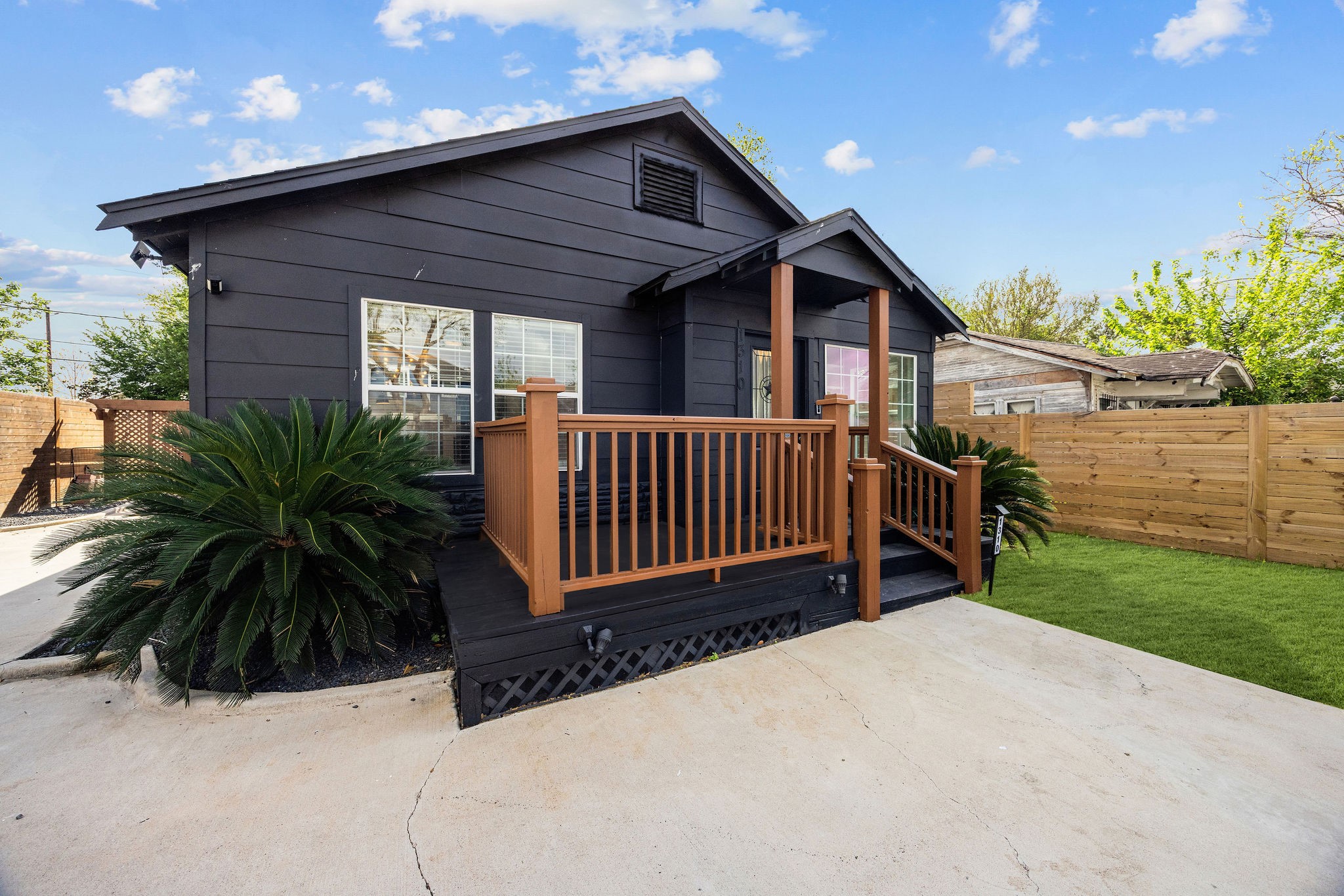 1310 Walton Street Houston, TX 77009 - Photo 2 of 19 Striking modern exterior with bold dark siding, warm wood accents, and a welcoming front porch.