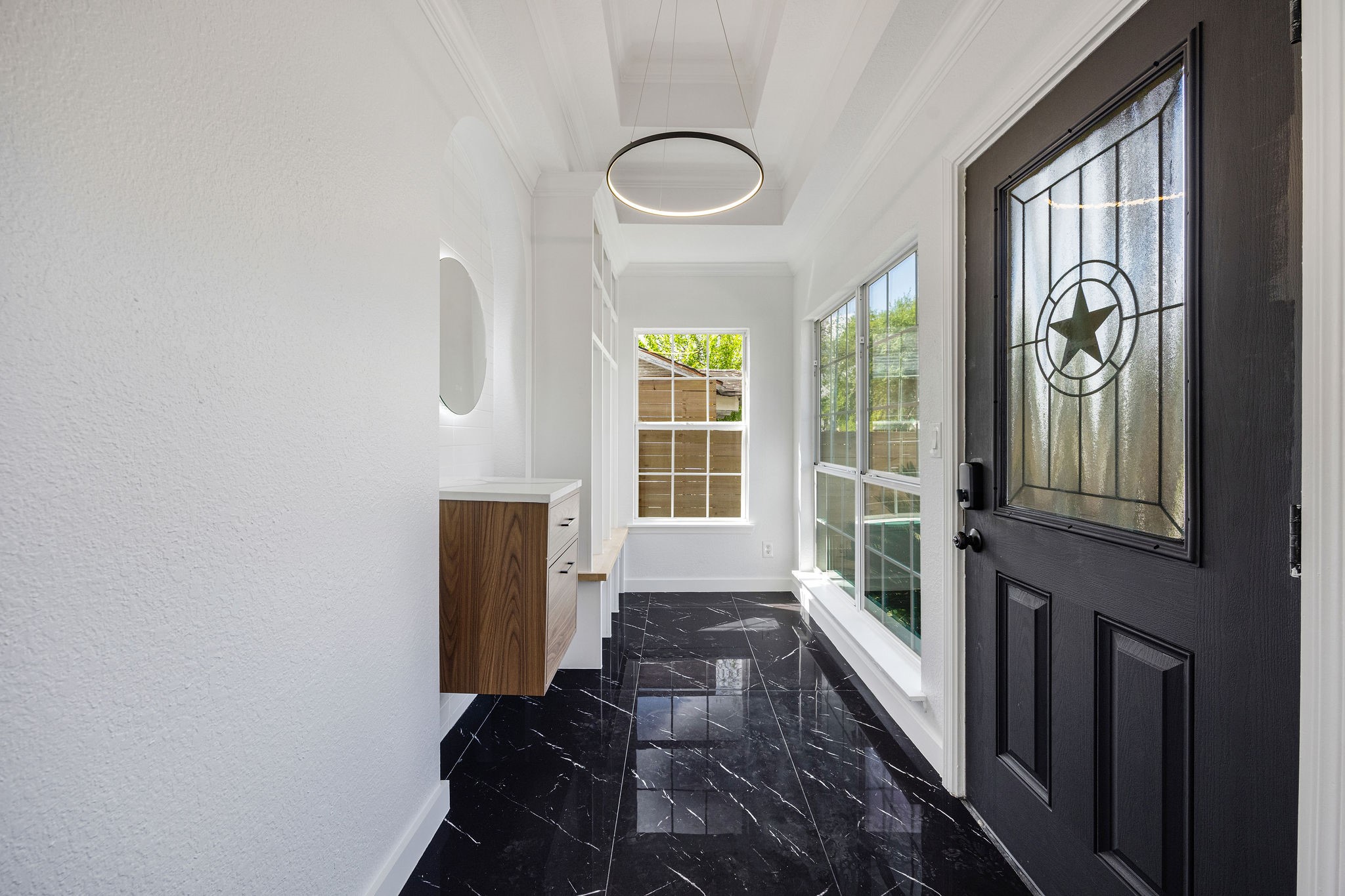 1310 Walton Street Houston, TX 77009 - Photo 3 of 19 Bright and inviting entryway with designer lighting, sleek tile flooring, and custom built-in details.