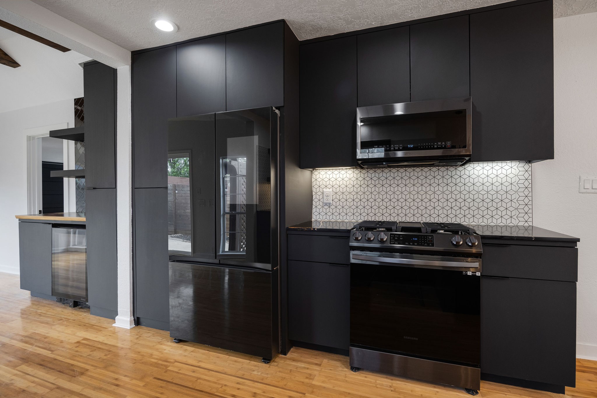 1310 Walton Street Houston, TX 77009 - Photo 7 of 19 Modern kitchen design with floating shelves, statement tile backsplash, and sleek finishes.