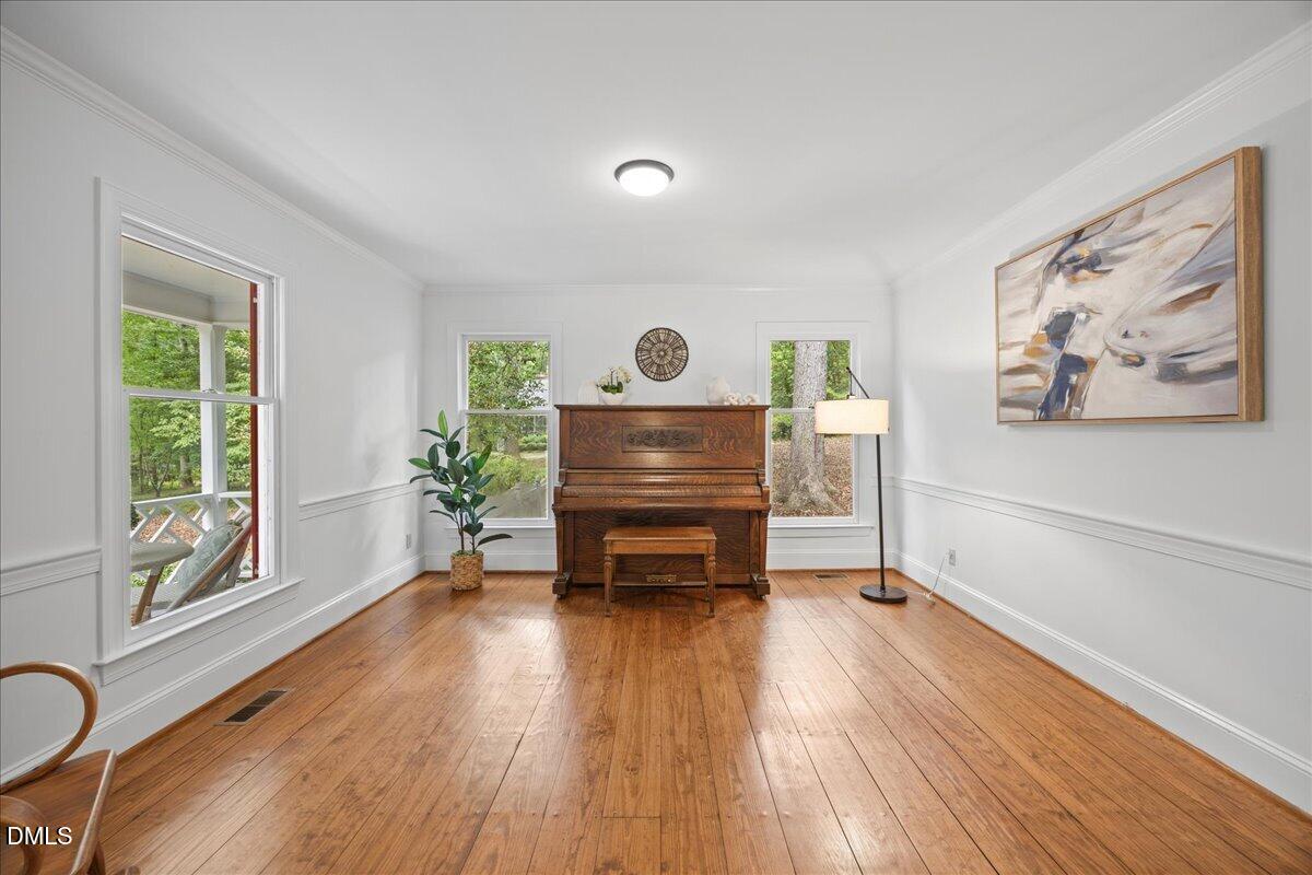 6516 Bakersfield Drive Raleigh, NC 27606 - Photo 27 of 59 a living room with furniture and a wooden floor