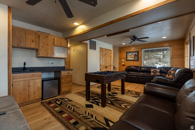 1505 West Elk Ridge Drive Alton, UT 84710 - Photo 30 of 53 Living room featuring ceiling fan, a textured ceiling, light wood-style flooring, wooden walls, and recessed lighting