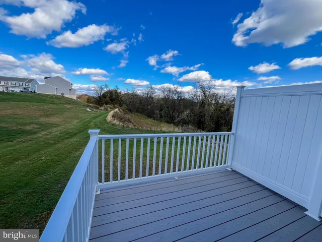a view of balcony with wooden floor & fence