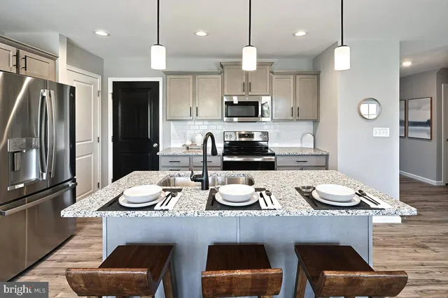 a kitchen with a table chairs stove and wooden floor