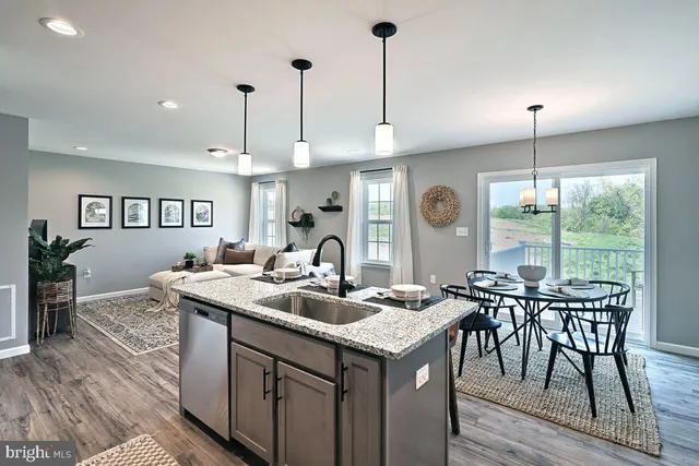 a kitchen with kitchen island granite countertop a sink a counter space appliances and cabinets