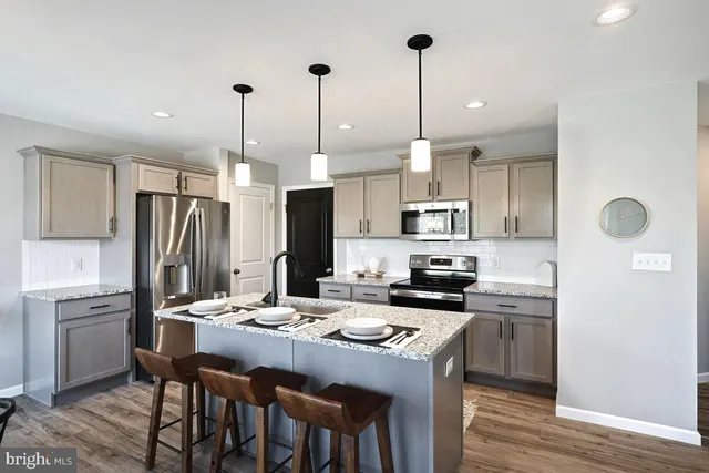 a kitchen with granite countertop kitchen island stainless steel appliances a sink stove and refrigerator
