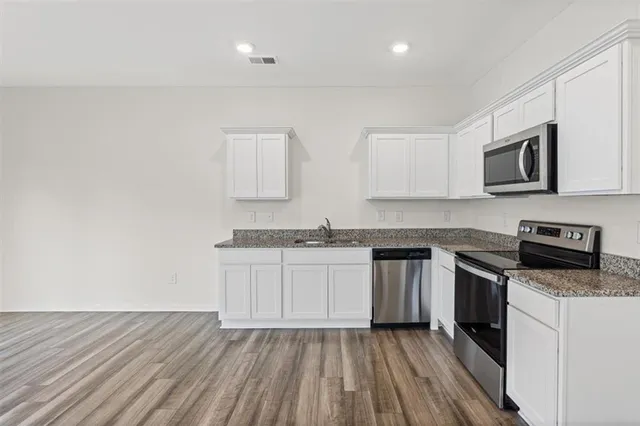a kitchen with sink a microwave and cabinets