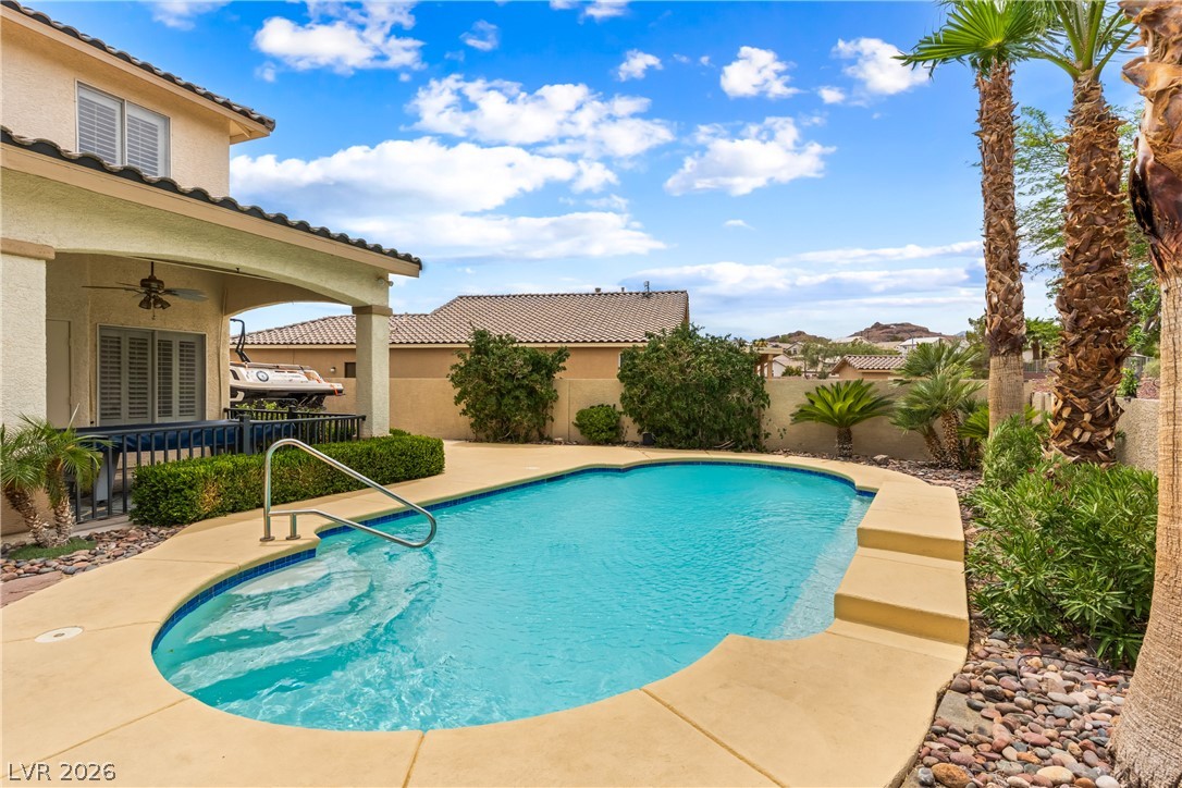 708 Vortex Avenue Henderson, NV 89002 - Photo 50 of 71 An inviting backyard oasis offers a sparkling in-ground pool surrounded by lush landscaping and a covered patio.