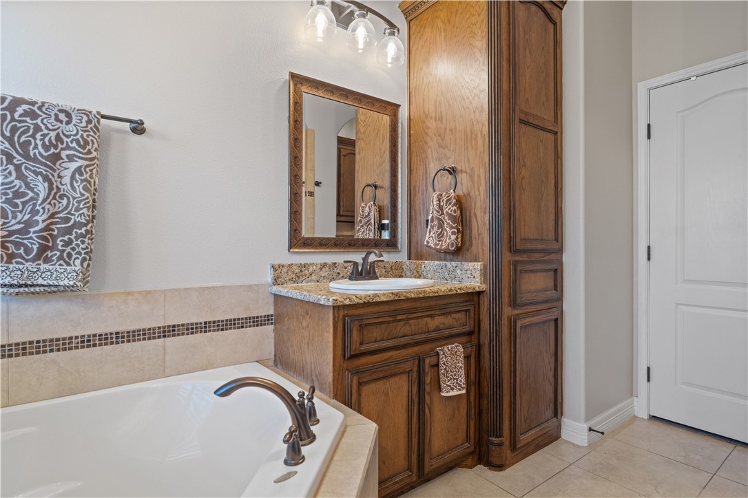 6934 Wooldridge Road, Unit K Corpus Christi, TX 78414 - Photo 14 of 20 a spacious bathroom with a granite countertop bathtub a sink and a mirror