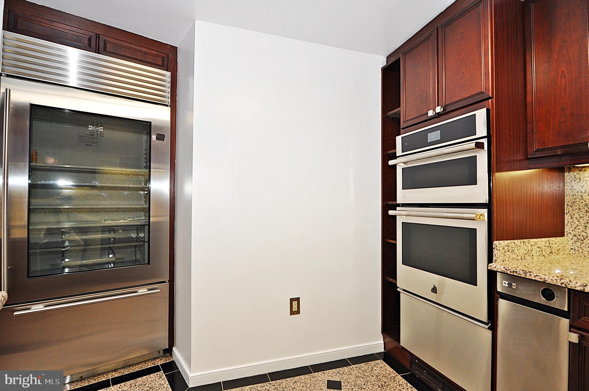 3030 K Street Northwest, Unit 204 Washington, DC 20007 - Photo 9 of 34 a kitchen with wooden cabinets and stainless steel appliances