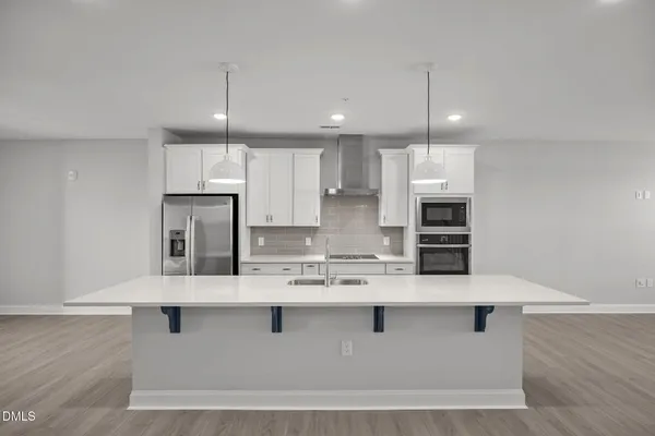 a kitchen with kitchen island stainless steel appliances a sink refrigerator and microwave