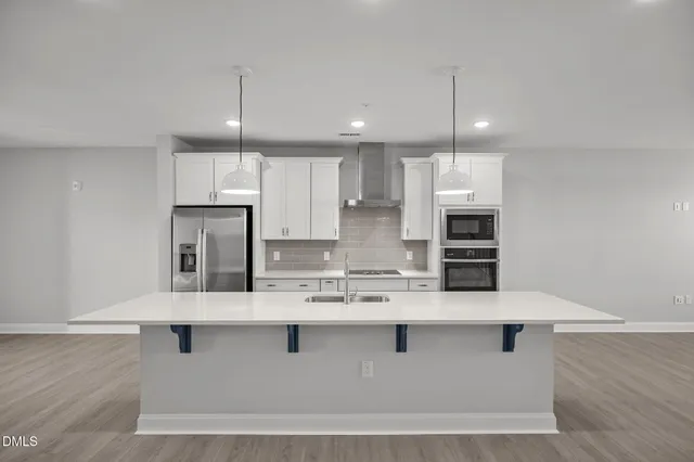 a kitchen with kitchen island stainless steel appliances a sink refrigerator and microwave