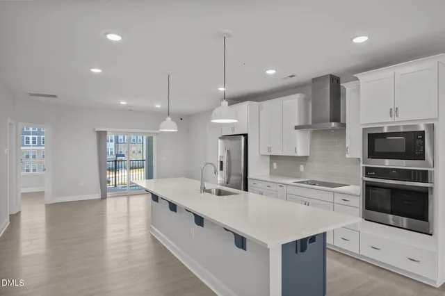 a large kitchen with kitchen island a sink stainless steel appliances and cabinets