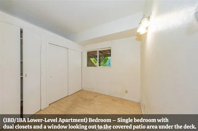 a view of a hallway with wooden floor and a bathroom