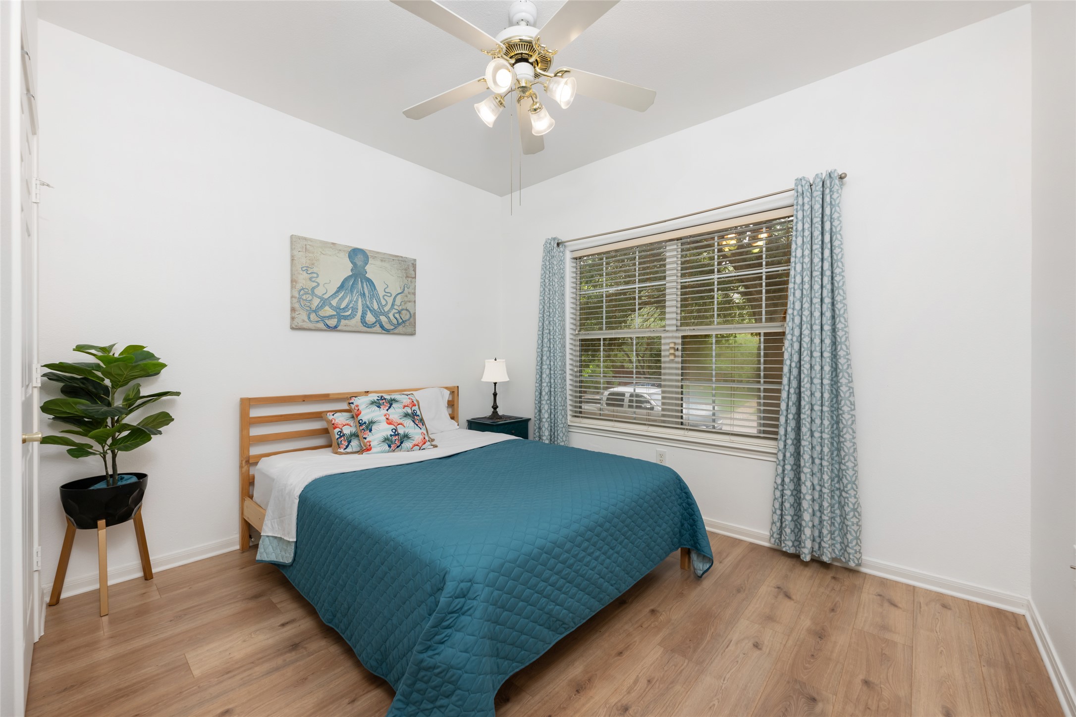 5613 Signal Point Austin, TX 78724 - Photo 7 of 21 Room featuring light wood-finish flooring, a window with blinds and patterned drapes, a ceiling fan with integrated lighting, and white walls