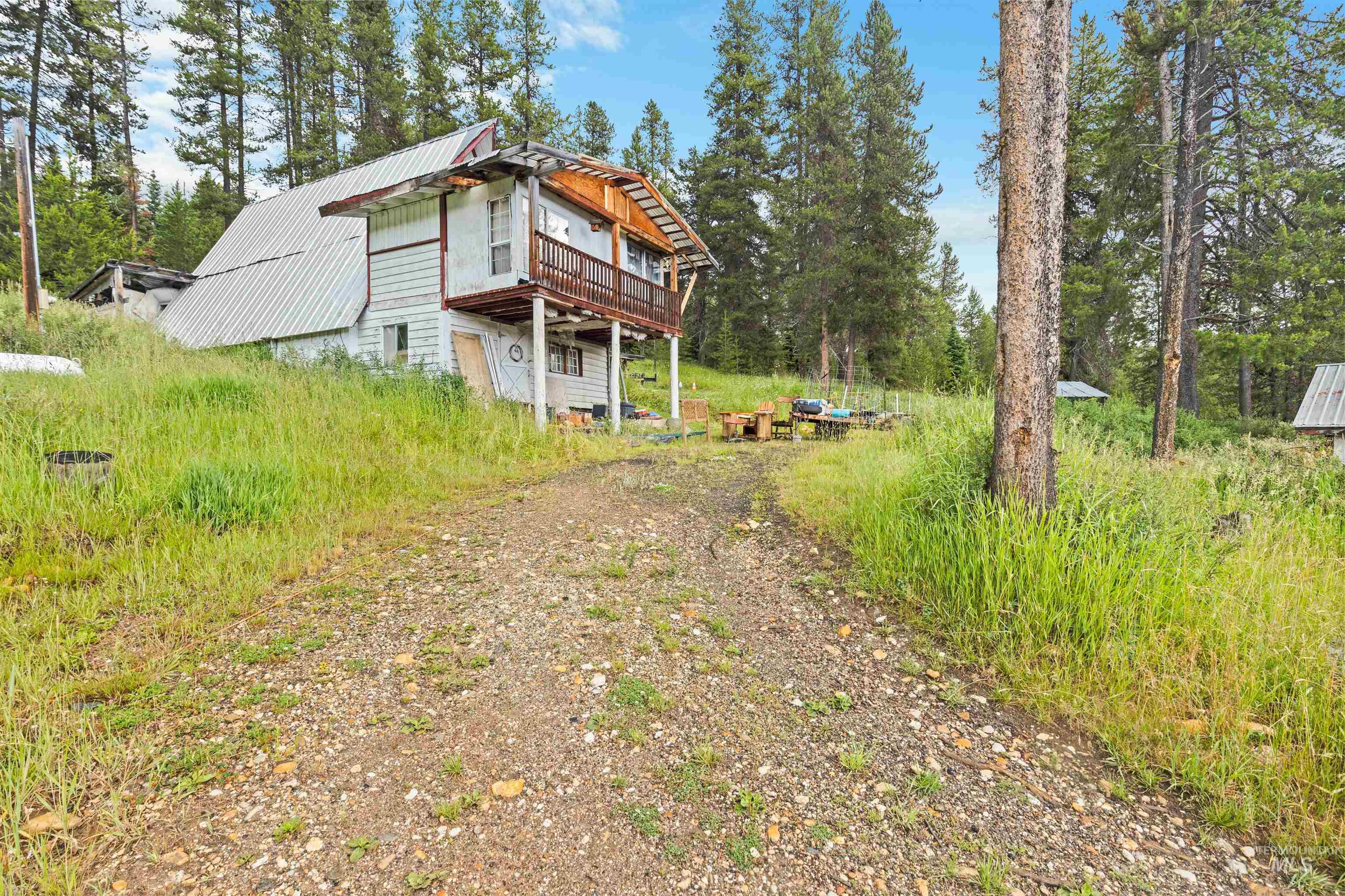 101 Hidden Springs Road Elk City, ID 83525 - Photo 17 of 28 Expansive rural property featuring a primary residence with a red roof, multiple outbuildings, and a detached garage/workshop