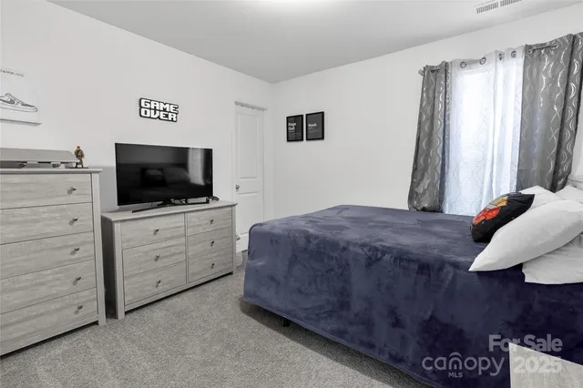 a bedroom with a bed and flat screen tv