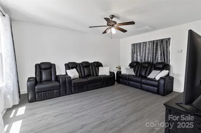 a living room with furniture and a wooden floor