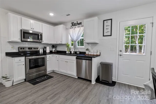 a kitchen with kitchen island granite countertop a stove a sink and a microwave