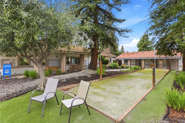 a view of a house with backyard and sitting area