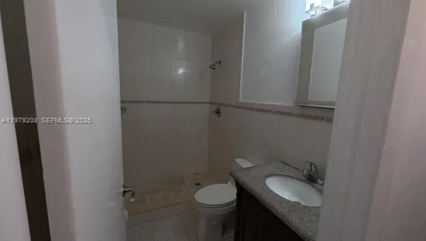 a bathroom with a granite countertop toilet and sink