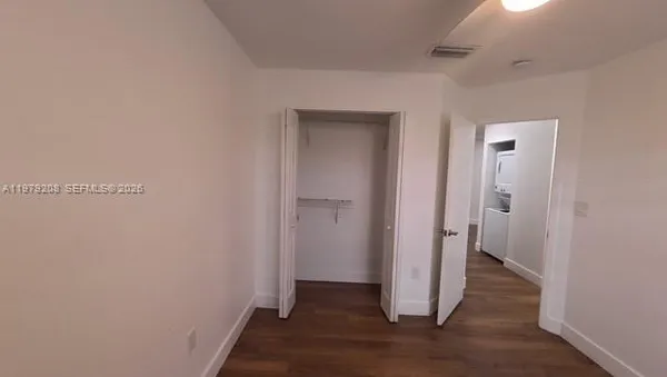 a view of a hallway with wooden floor and closet