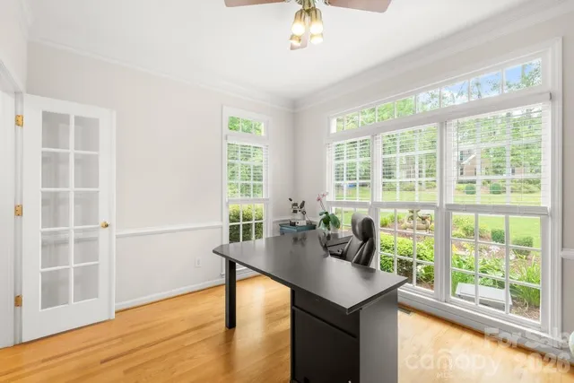 a kitchen with stainless steel appliances kitchen island granite countertop a refrigerator a stove a dining table and chairs with wooden floor