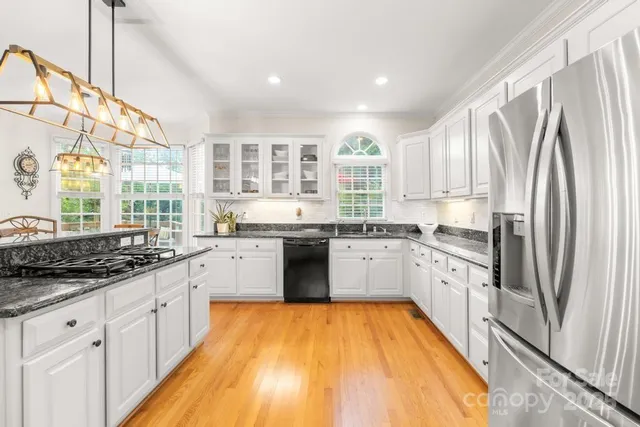 a kitchen with stainless steel appliances granite countertop a stove a sink and a refrigerator