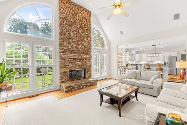 a living room with fireplace furniture and a large window