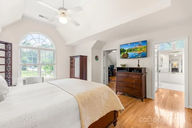 a bedroom with a bed and a large window with the outer view