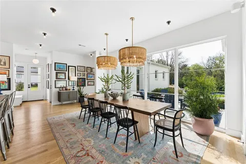 a view of a dining room and livingroom with furniture wooden floor a chandelier