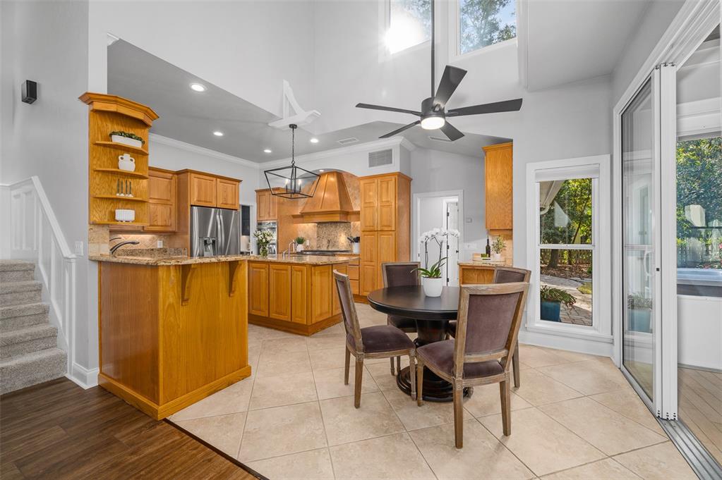 4524 Southwest 105th Drive Gainesville, FL 32608 - Photo 19 of 56 a dining room with stainless steel appliances kitchen island granite countertop a table and chairs