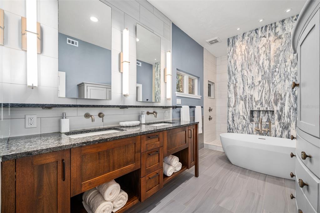 4524 Southwest 105th Drive Gainesville, FL 32608 - Photo 30 of 56 a bathroom with a double vanity sink a mirror a bathtub and shower