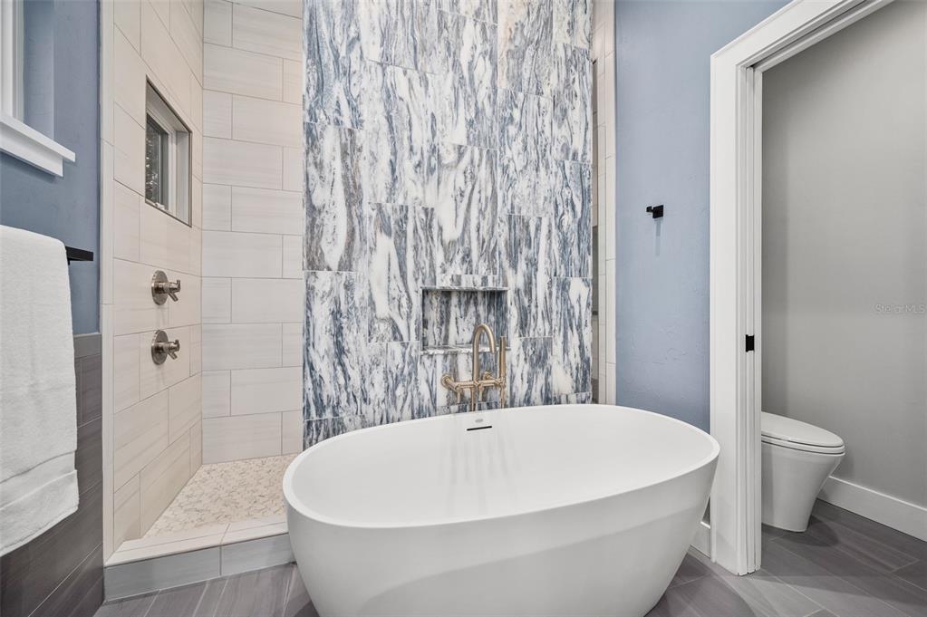 4524 Southwest 105th Drive Gainesville, FL 32608 - Photo 35 of 56 a white bath tub sitting next to a white toilet