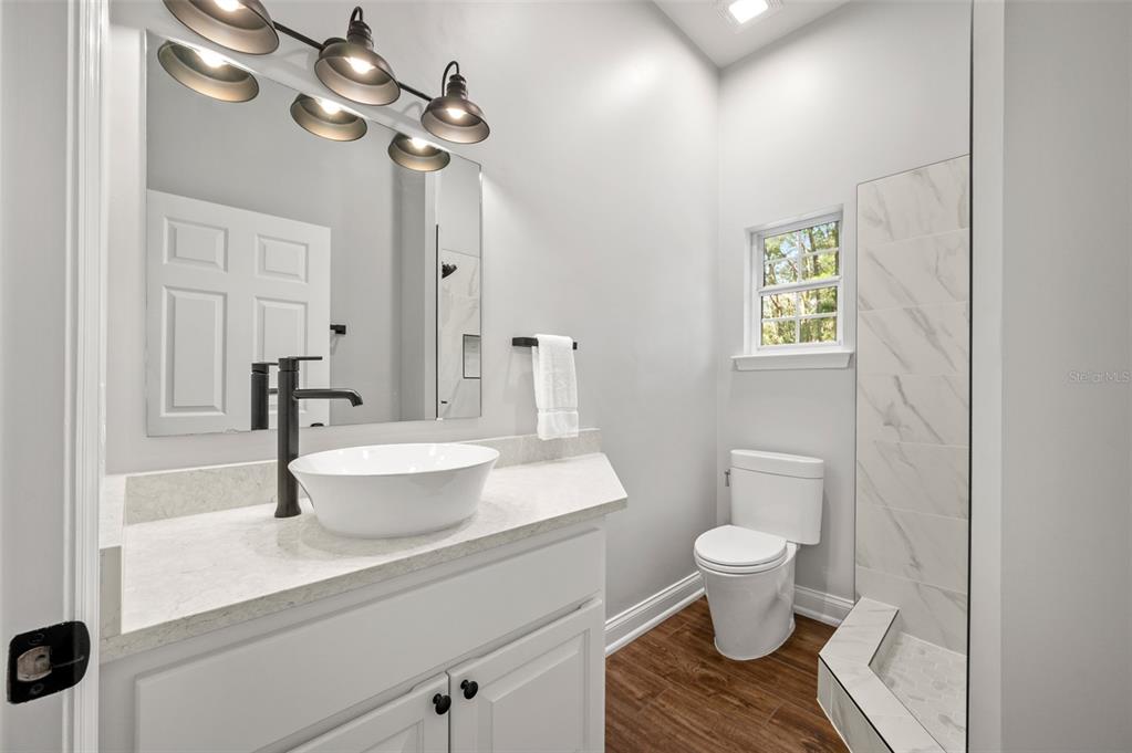4524 Southwest 105th Drive Gainesville, FL 32608 - Photo 37 of 56 a bathroom with a toilet a sink and a mirror