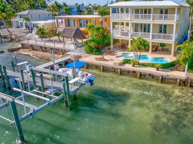 a view of a swimming pool with lawn chairs and plants