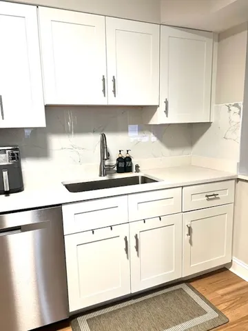 a kitchen with white cabinets and white appliances