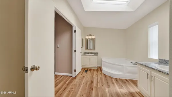 a bathroom with a granite countertop sink and white cabinets